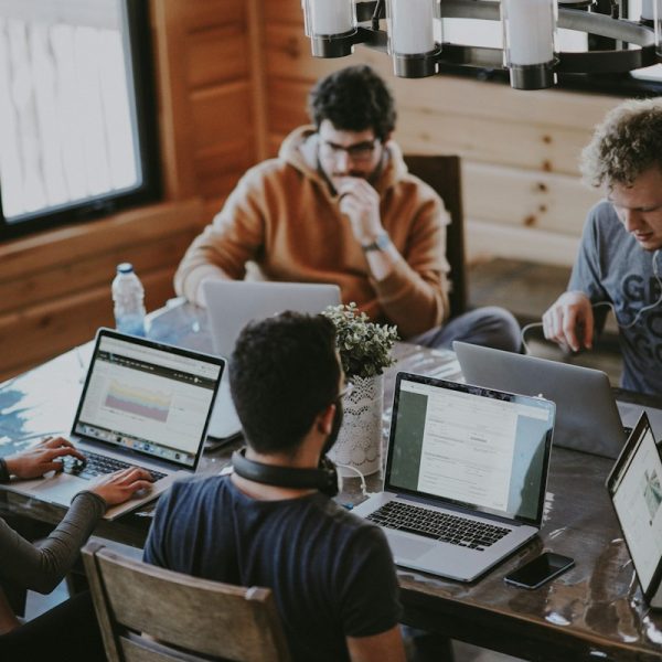 men sitting in front of their laptop computer